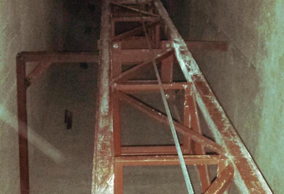 Отгрузка и установка мачтового подъемника в лифтовой шахте жилого высокоэтажного дома.